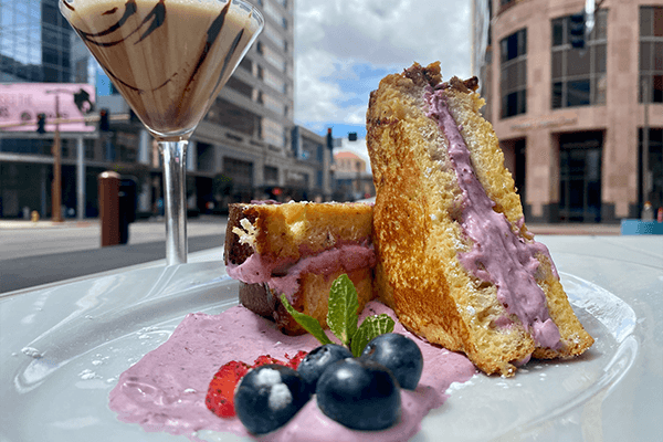 Delicious cheesecake with berry filling, decorated with berries, cream and mint leaf