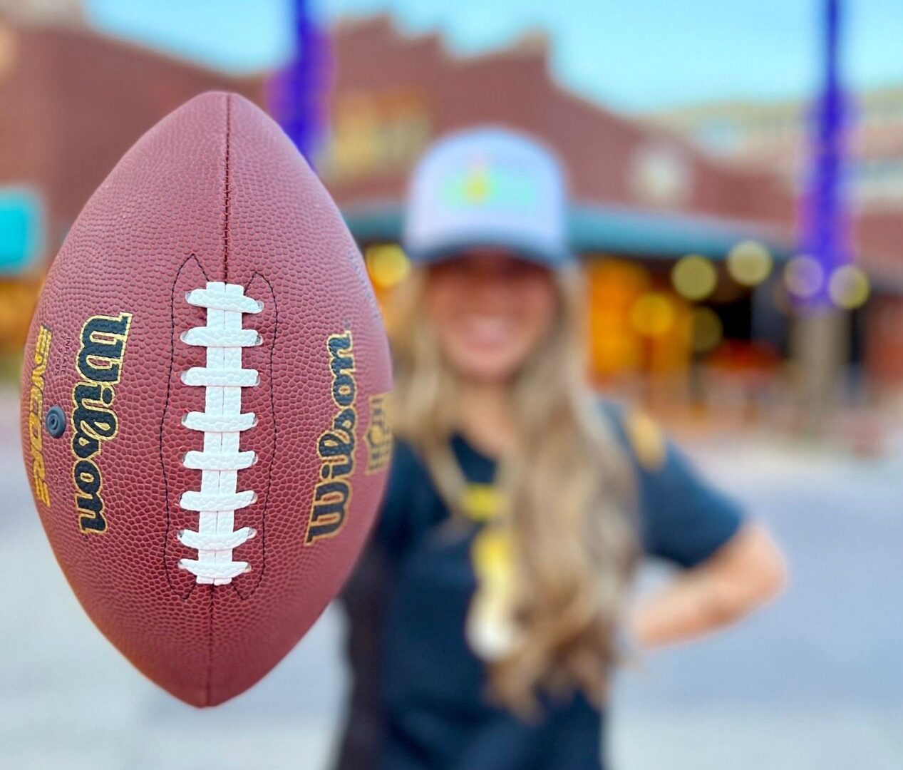 Morning Squeeze staff holds a super football in the foreground welcoming visitors for brunch.