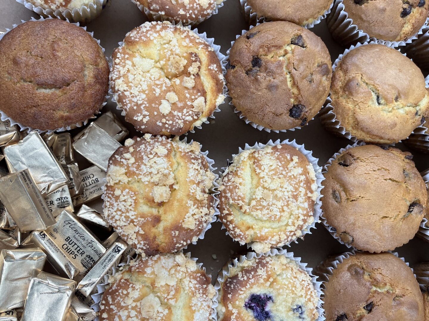 variety of wrapped muffins in a box.