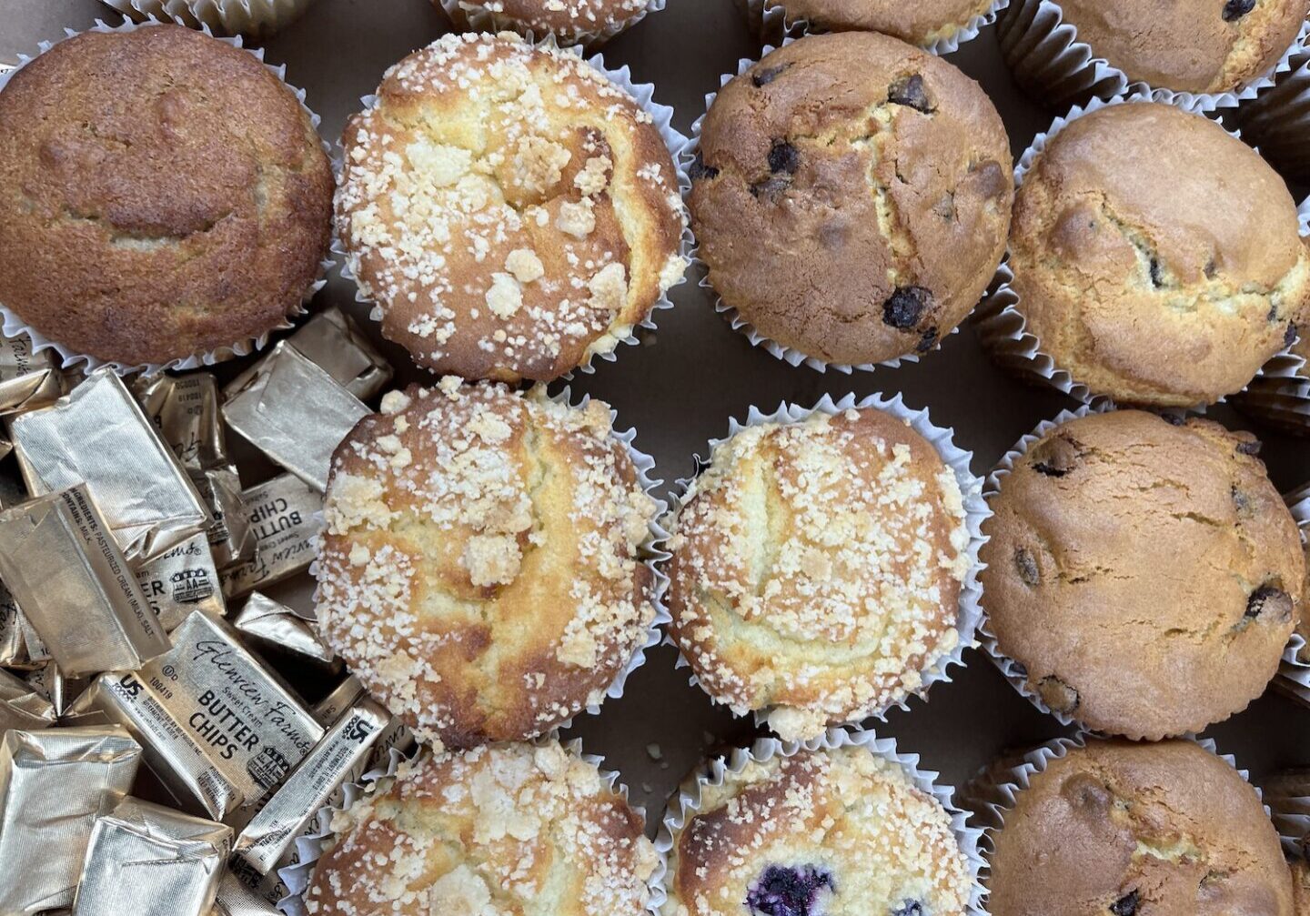 variety of wrapped muffins in a box.